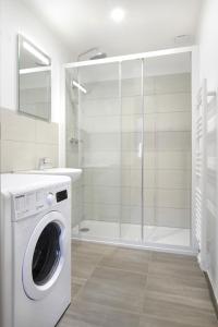 una lavatrice in un bagno con doccia di Heptagone_2 a Saint-Quentin