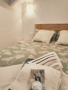 a bed with a book sitting on top of it at La casita del olivo in Hervás