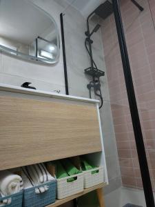 a bathroom with a sink and a cabinet with towels at La casita del olivo in Hervás