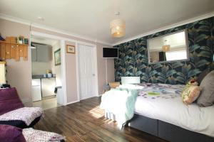 a bedroom with a large bed and a mirror at Peaceful Garden Apartment in Herne Bay