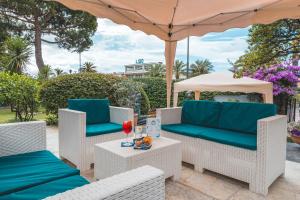 patio z krzesłami, parasolem i stołem w obiekcie Hotel Santa Maria w mieście Chiavari