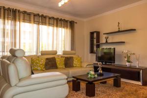 a living room with a couch and a tv at Apartamento Batista by Horizon View Madeira in Funchal