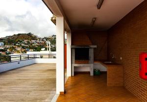 uma varanda com piso em madeira e uma parede de tijolos em Apartamento Batista by Horizon View Madeira no Funchal