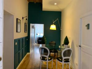 a dining room with a green wall and a table and chairs at Urbana 33 in Rome
