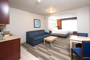 a living room with a couch and a bed in a room at Holiday Inn Express Hotel & Suites Grand Blanc, an IHG Hotel in Grand Blanc