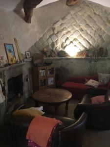 ein Wohnzimmer mit einem Sofa und einem Tisch in der Unterkunft Prieuré St Jean à Autichamp in Autichamp