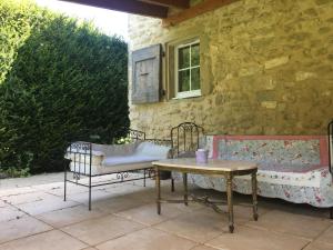 eine Terrasse mit 2 Bänken und einem Tisch in der Unterkunft Prieuré St Jean à Autichamp in Autichamp