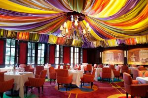 ein Esszimmer mit Tischen und Stühlen und einer Decke in der Unterkunft Bellagio in Las Vegas + 37 Fotos