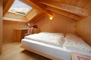 een slaapkamer met een bed op zolder bij Grohmann Apartments in Selva di Val Gardena