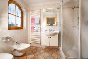 een badkamer met wastafel, douche en toilet bij Grohmann Apartments in Selva di Val Gardena +18 foto's
