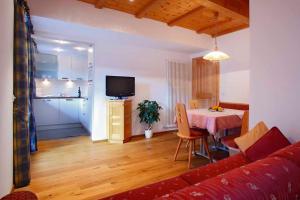 een woonkamer met een rode bank en een tafel bij Grohmann Apartments in Selva di Val Gardena