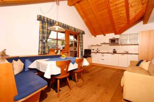 een keuken en eetkamer met een tafel en stoelen bij Grohmann Apartments in Selva di Val Gardena
