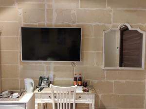 a desk with a television on a brick wall at Central 214 Boutique Hotel in Hamrun