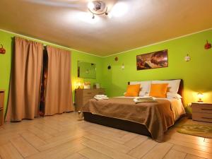 a bedroom with green walls and a bed with orange pillows at Maison Zazà Naples in Naples