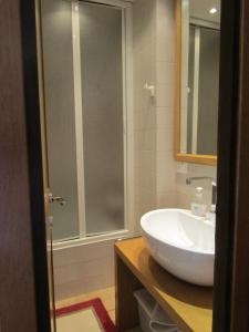 W łazience znajduje się biała umywalka i prysznic. w obiekcie Chalet Vicino a Cortina w mieście Borca di Cadore