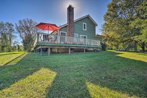 Casa con terraza grande con sombrilla roja en Lovettsville Cottage in Heart of Wine Country, en Lovettsville