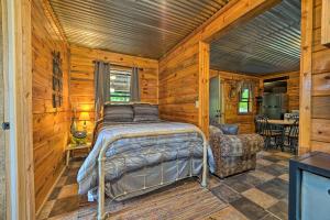 a bedroom with a bed and a chair in a cabin at Wright City Cabin with Fire Pit and Forest Views! in Wright City