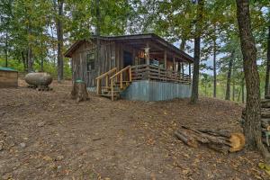 a wooden cabin in the middle of a forest at Wright City Cabin with Fire Pit and Forest Views! in Wright City