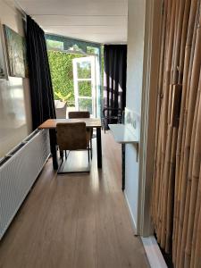 comedor con mesa y silla en East Meets West Bed and Breakfast, en Veenendaal