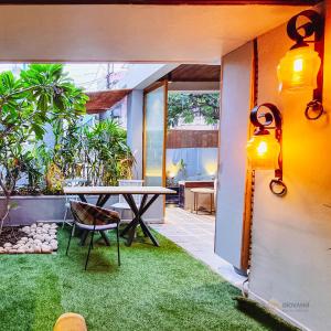 an outdoor patio with a table and grass at Giovanni House in Bhopal