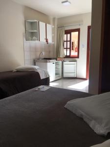 a hotel room with two beds and a kitchen at Villa Apart Hotel in Lages