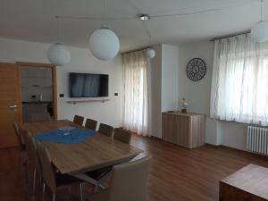 パッソ・デル・トナーレにあるAppartamento DIAMANTEのテーブルと椅子とテレビのあるダイニングルーム