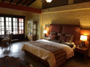 ein Schlafzimmer mit einem großen Bett, einem Tisch und Stühlen in der Unterkunft Monasterio San Agustín, Colombia in San Agustín