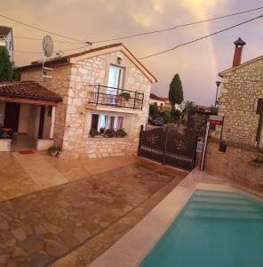 una casa con una piscina y un arco iris en el fondo en Casa Ladonja en Poreč