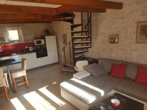 sala de estar con sofá y escalera de caracol en Casa Ladonja, en Poreč