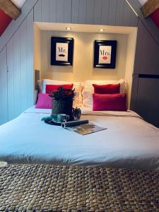 オーストカンプにあるFlemish cottageのベッドルーム(赤い枕の大きな白いベッド付)