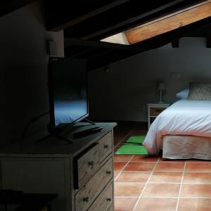 
a bedroom with a bed and a dresser at Posada del tiempo in Villavieja del Lozoya
