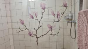 a painting of a pink flower on the wall of a shower at Pension Vinařství Klučov in Klučov