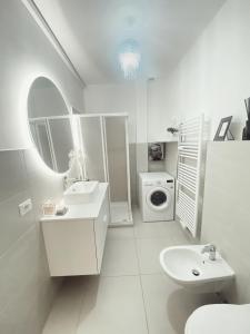 a white bathroom with a sink and a washing machine at Chic In The City in Bolzano