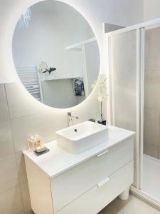 a white bathroom with a sink and a mirror at Chic In The City in Bolzano