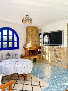 a living room with a table and a fireplace at Dmina House in Asilah