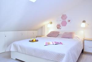 a bedroom with a white bed with a bowl of fruit on it at Apartments Sea & Sky in Stari Grad