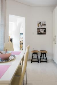 a dining room with a table and two stools at Μονοκατοικία «Maizonette passaggio G» in Volos