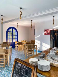 a dining room with a table with plates on it at Dmina House in Asilah