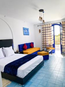a bedroom with a large bed and a couch at Dmina House in Asilah +37 photos