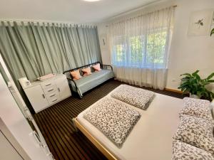 een slaapkamer met 2 bedden en een raam bij Family Guesthouse GreenSLO in Ljubljana