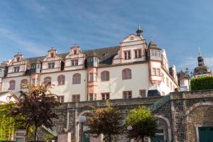 ein großes weißes Gebäude mit einem Dach in der Unterkunft Schlosshotel Weilburg in Weilburg