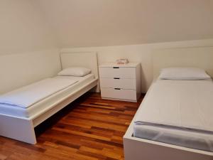 ein Schlafzimmer mit 2 Betten und einer Kommode darin in der Unterkunft Appartment Himmelblau in Friedrichshafen