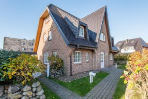 a large brick house with a gambrel roof at Haus Osterweg 8 Whg 13 in Wenningstedt