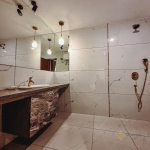 La salle de bains est pourvue d'un lavabo et d'une douche. dans l'établissement Giovanni House, à Bhopal