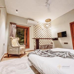 sypialnia z łóżkiem, krzesłem i oknem w obiekcie Giovanni House w mieście Bhopal