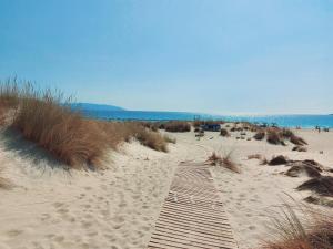 a wooden path in the sand on a beach at Simos suites in Elafonisos