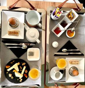 カオールにあるTroisième Droiteのテーブルの上に朝食用の食品とドリンクのトレイ