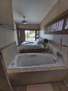 una vasca da bagno in una camera con letto di Whale Rock, Modern Beachfront Apartment a Margate