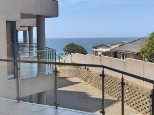 a view of the ocean from the balcony of a house at Whale Rock, Modern Beachfront Apartment in Margate