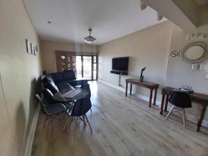 a living room with a couch and a table at Whale Rock, Modern Beachfront Apartment in Margate